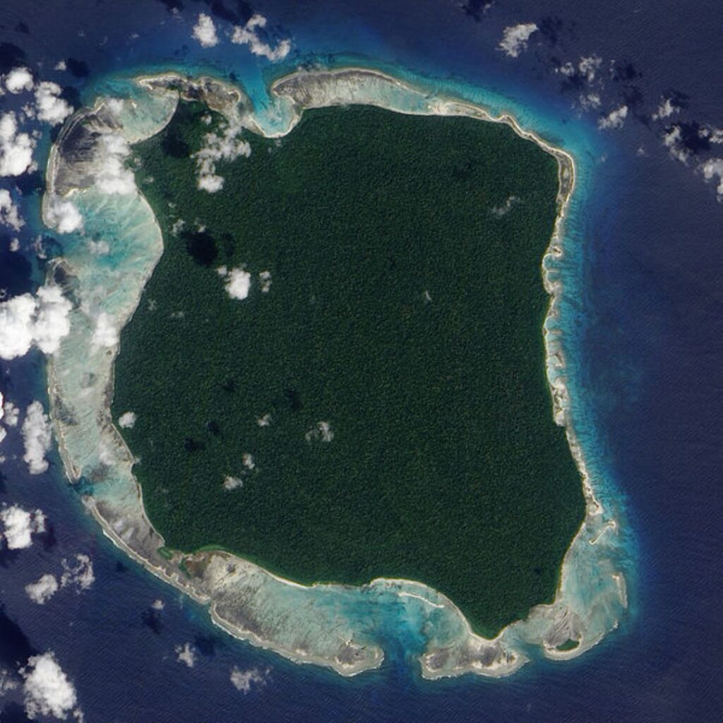 Satellite aerial view of a remote forested Andaman Island surrounded by clear ocean waters